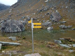 primo cartello per il Passo Zube nei pressi di un laghetto