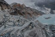 Al punto di ritorno: il lago, in primo piano l’ultimo ometto e le rocce su cui dovrebbe passare il percorso con dietro il pendio ormai spolverato